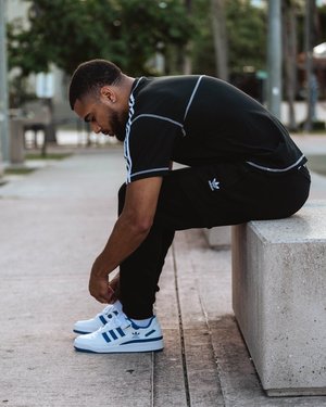 Basketball player holding adidas basketball watching players on a Miami court.