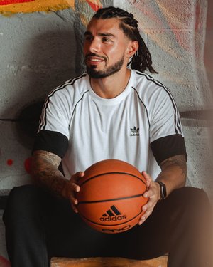 Latino male model posing for Adidas with basketball in hands