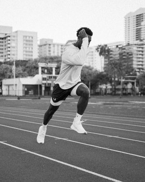 Black male fitness model sprinting on track