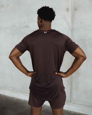 Black male fitness model posing for ASRV in front of a concrete wall