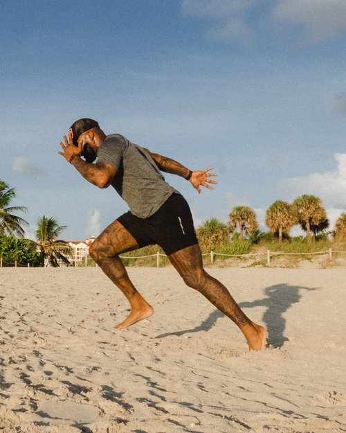 Football Athlete sprinting on beach during a workout.