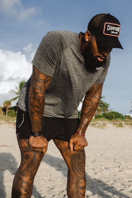 Football Athlete taking a breather during a morning beach workout.