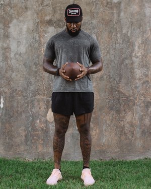 Black male athlete holding football
