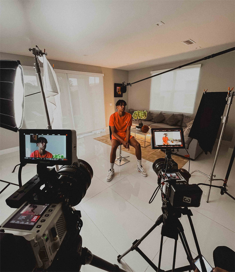 Basketball NBA player, Ousamne Dieng, in a living room, facing a camera for a video recording production for Adidas.