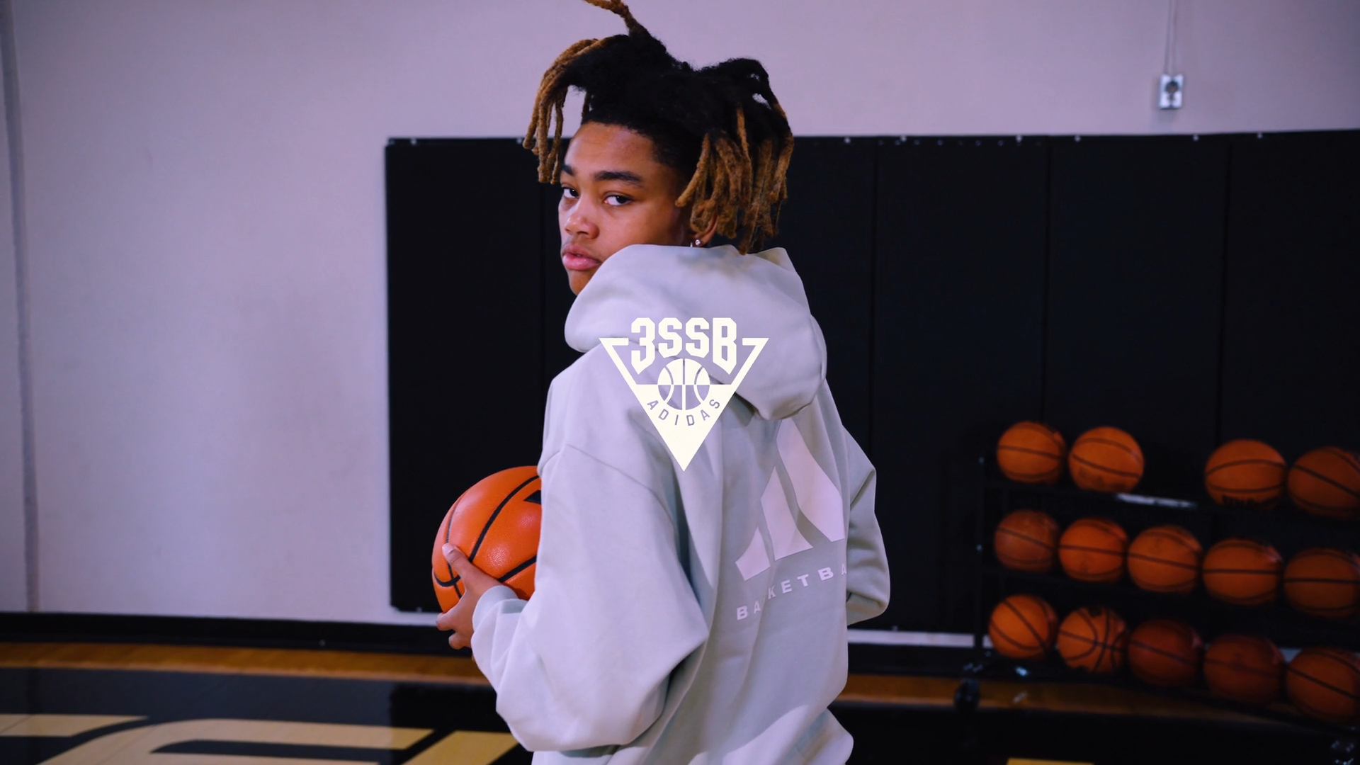 Young woman with dreadlocks holding an Adidas basketball for the girls 3SSB Adidas brand