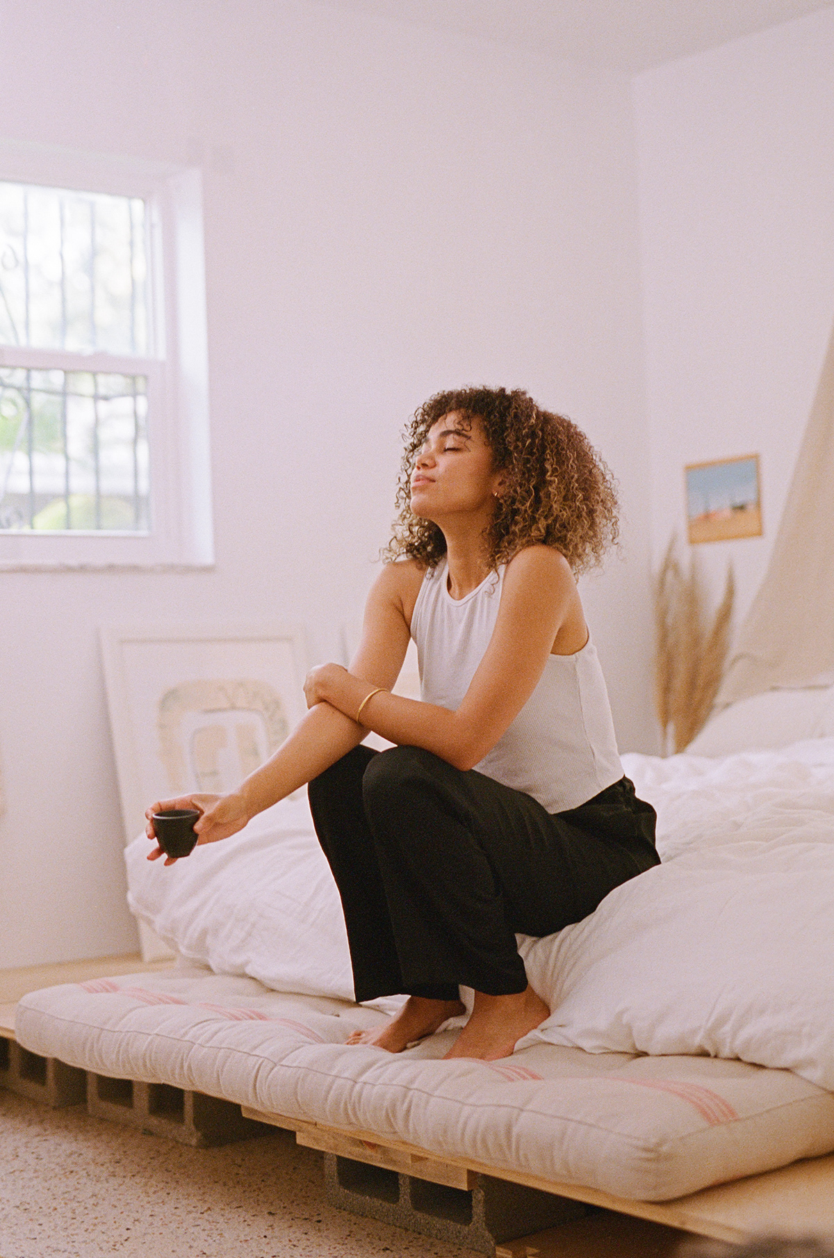 Female model drinking tea and taking a deep breath in the morning as she visualizes.